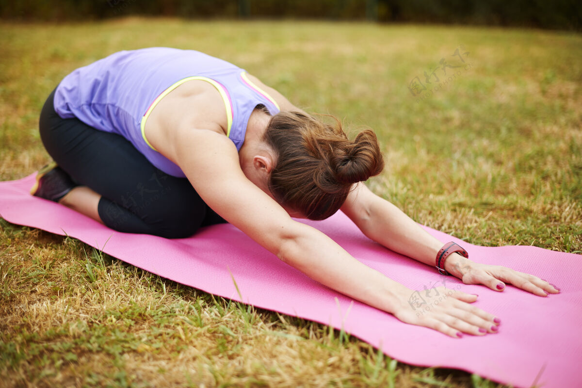 灵活运动后伸展非常重要年轻女子在户外做瑜伽休息健康锻炼