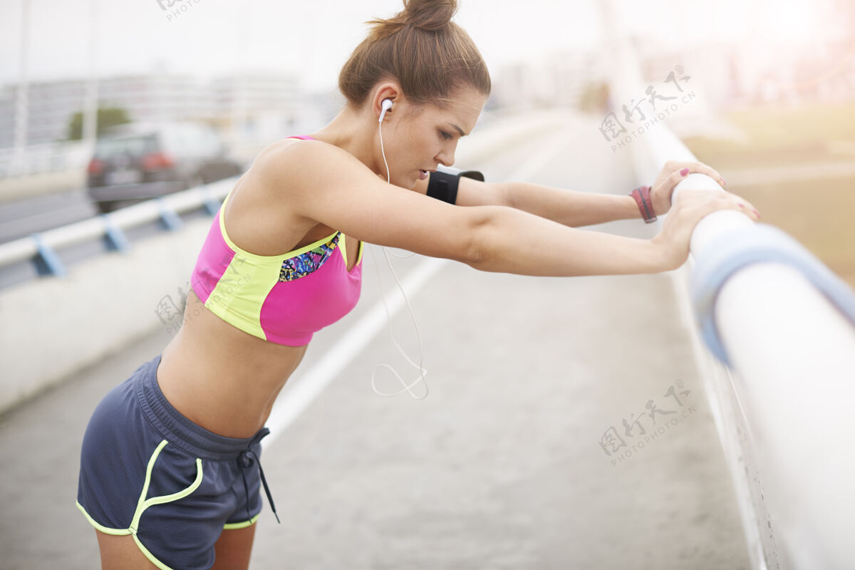 人体年轻女子在户外锻炼伸展运动是训练中非常重要的一部分热身健身力量