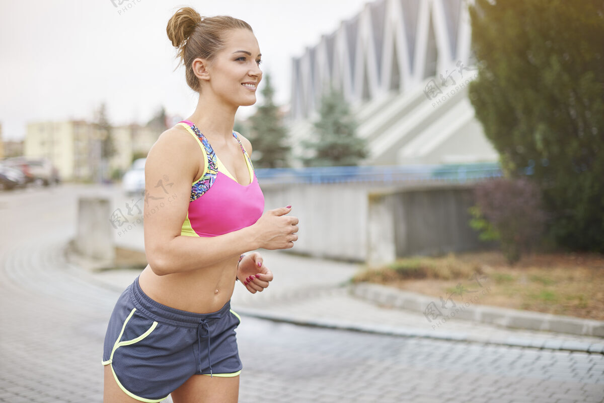 动作年轻女子慢跑或户外跑步城市给了很多机会去慢跑短裤腹部运动器材