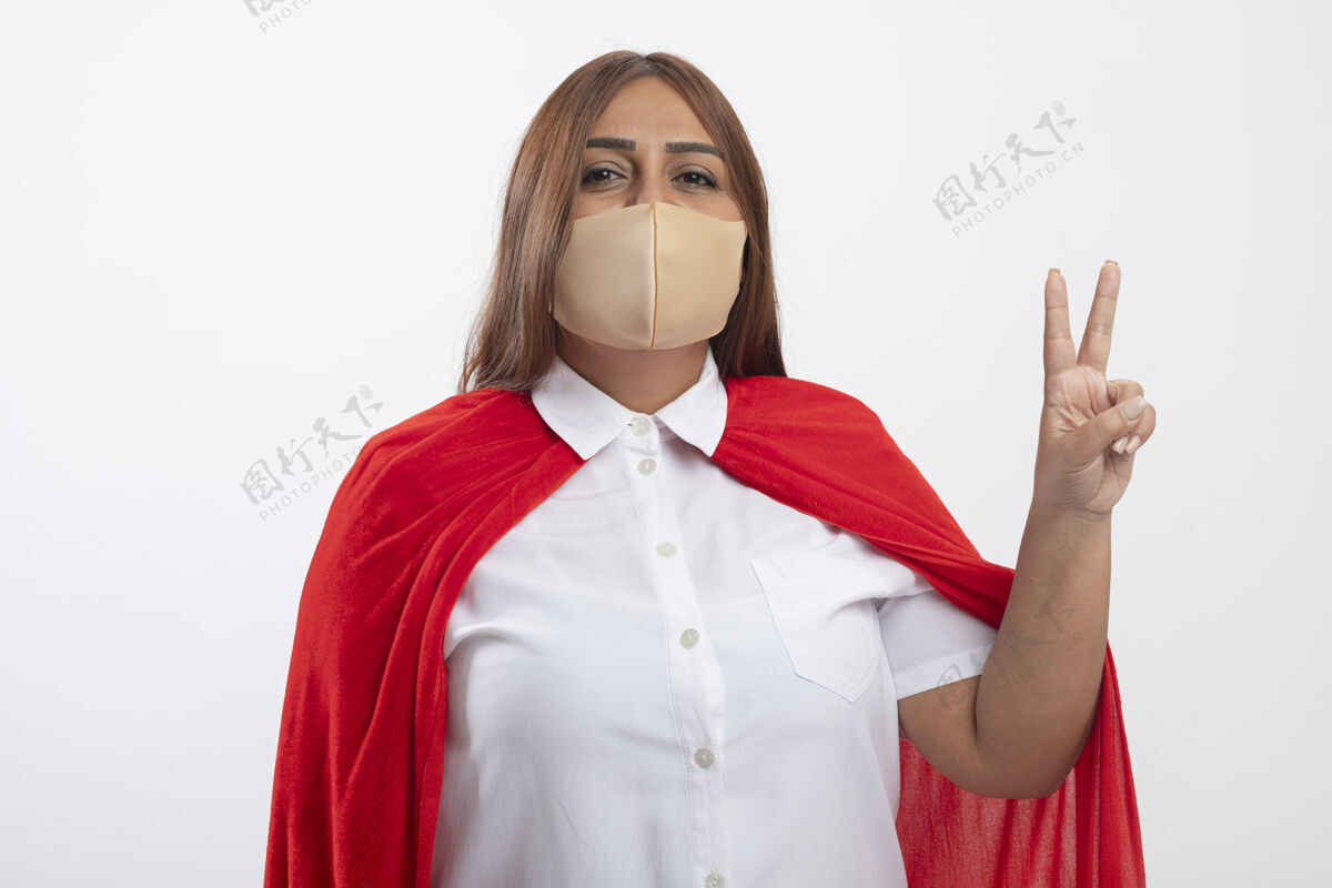 女性高兴的中年女超人戴着医用口罩显示和平姿态隔离在白色面具和平超级英雄