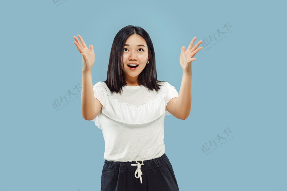 工作蓝色空间上的韩国年轻女子半身像穿白衬衫的女模特展示并指向某物手势韩语亚洲人