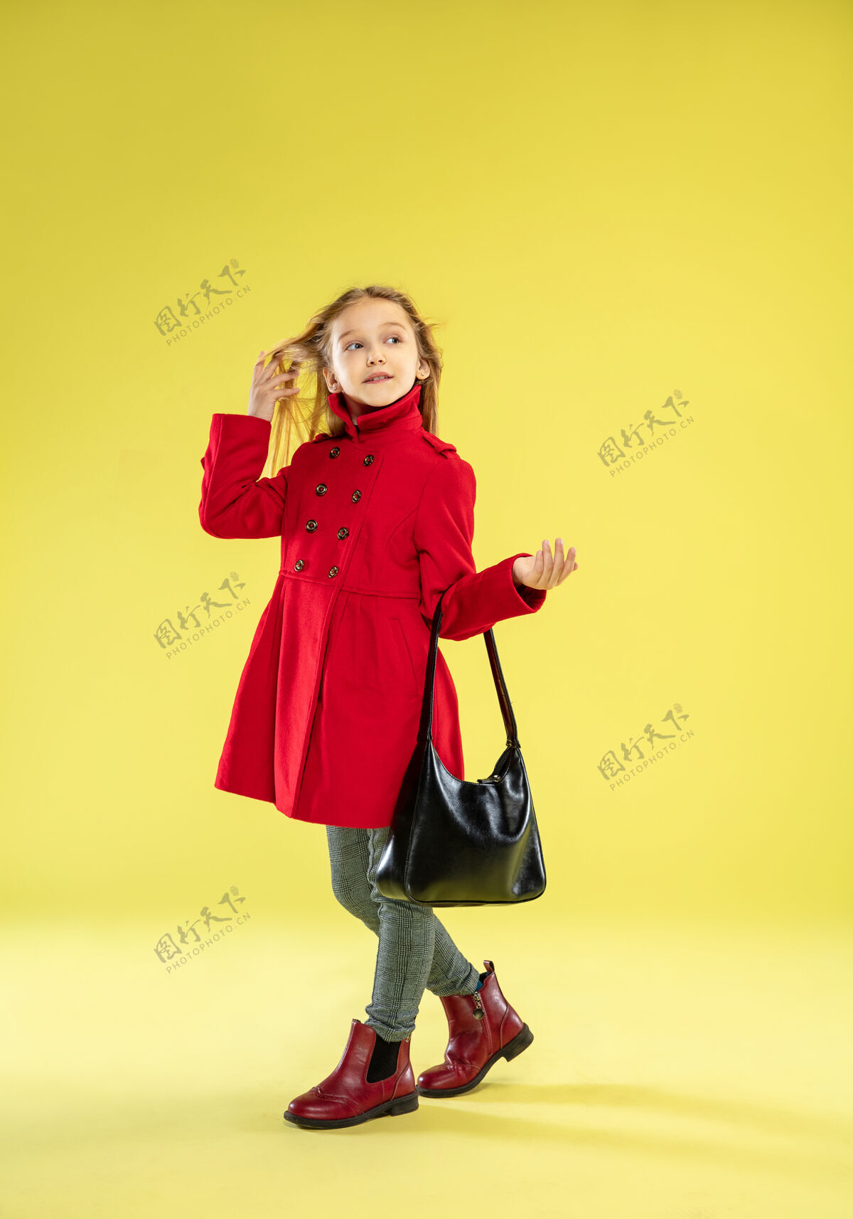 衣服一个穿着红色雨衣 带着黑色袋子的时髦女孩在黄色的工作室墙上摆出的一幅完整的肖像童年头发下雨