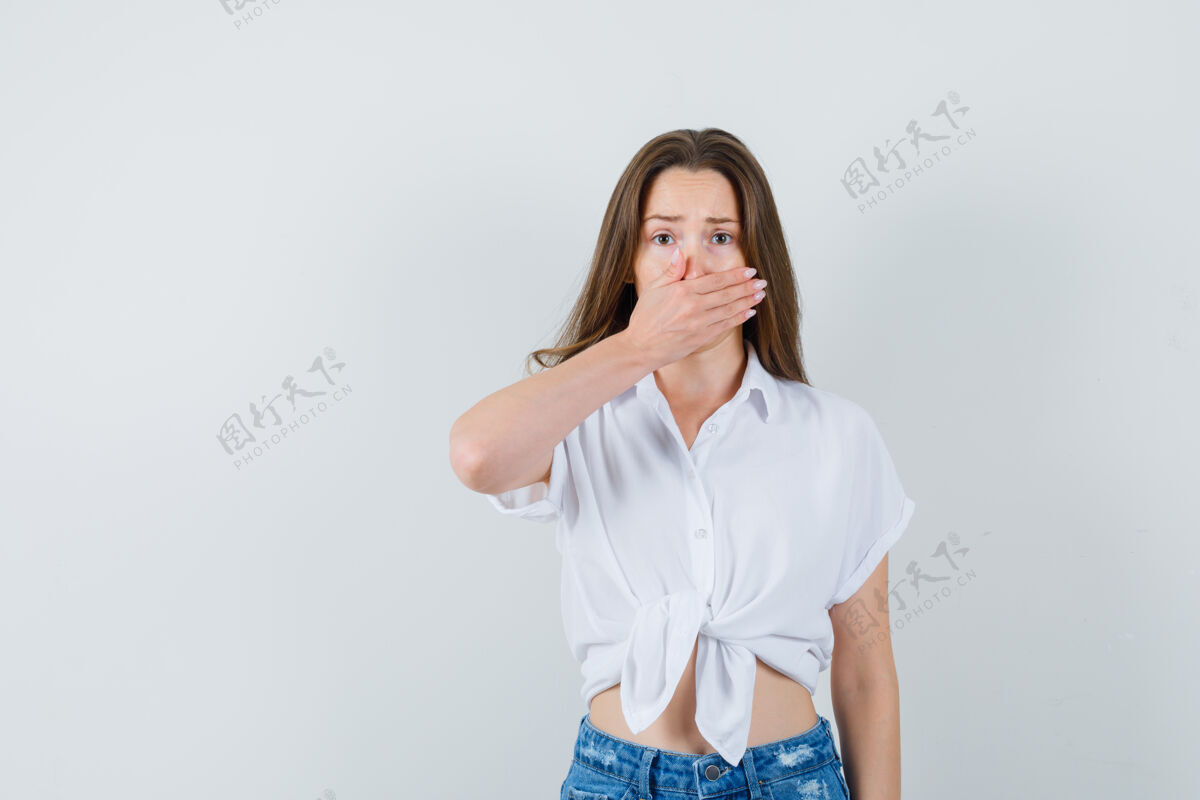 友谊穿着白衬衫的年轻女士手放在嘴上 看起来很害怕前视图微笑室内时尚