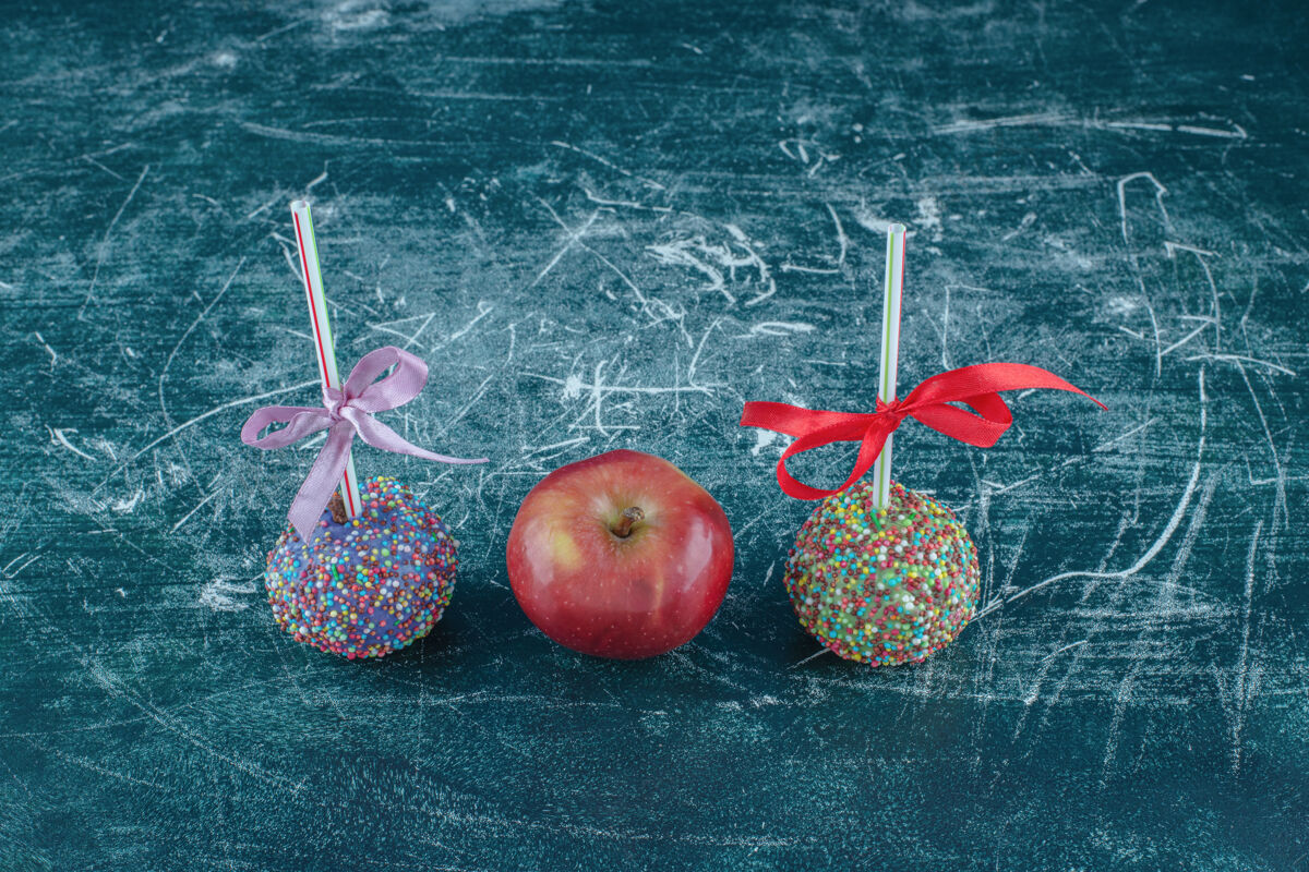 糖果糖果棒棒糖和蓝色背景上的苹果高品质的照片甜的外套新鲜的