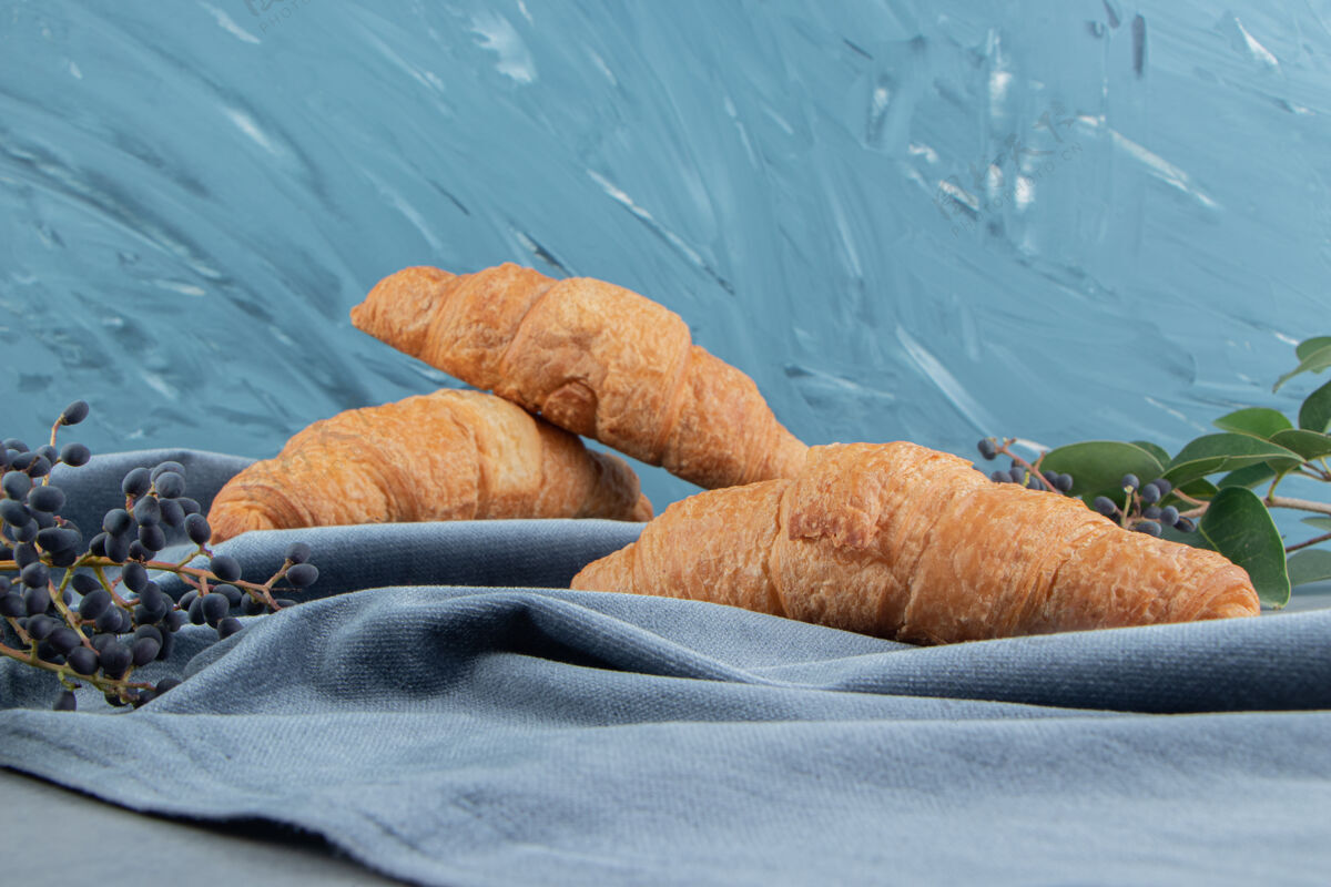 配料羊角面包放在毛巾上 葡萄放在大理石地板上 大理石背景上高质量的照片毛巾美味甜食