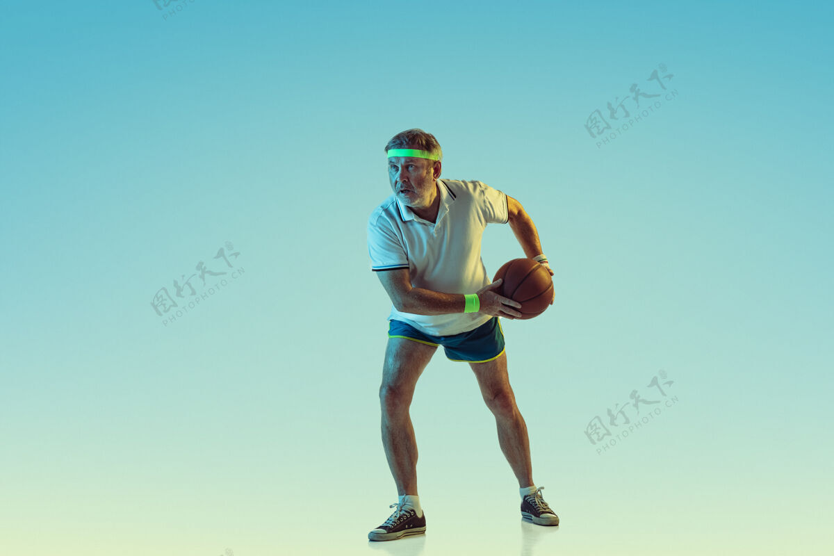 休闲高级男子在霓虹灯下的梯度背景下打篮球身材魁梧的白种人男模保持活跃 运动精神乐趣爱好设备