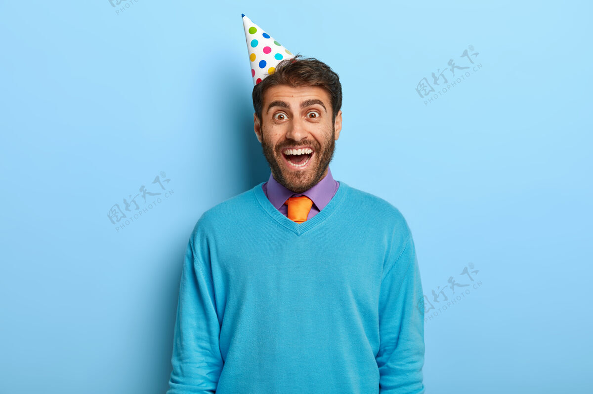 生日戴着生日帽 穿着蓝色毛衣的快乐男人男性男人欢乐