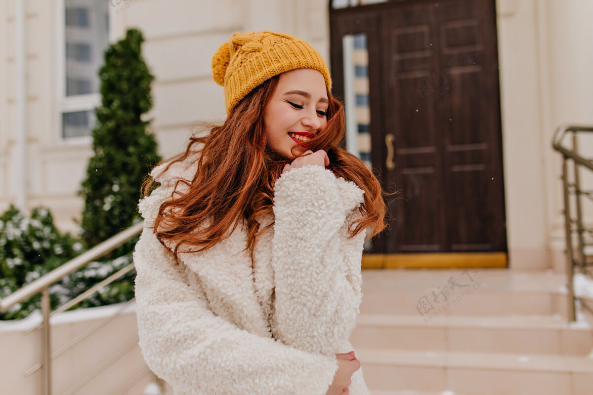 脸美丽的欧洲冬衣女士摆出迷人的微笑幸福的姜汁女孩表达积极的情绪外套季节年轻