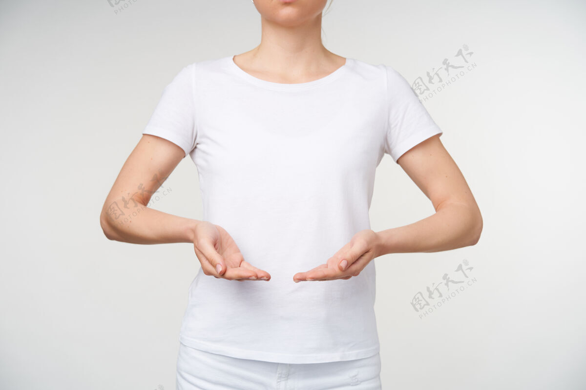 语言一张室内照片 年轻女子手挽着手 不用语言表达自己的想法 穿着白色t恤站在白色背景上庄稼站立手指
