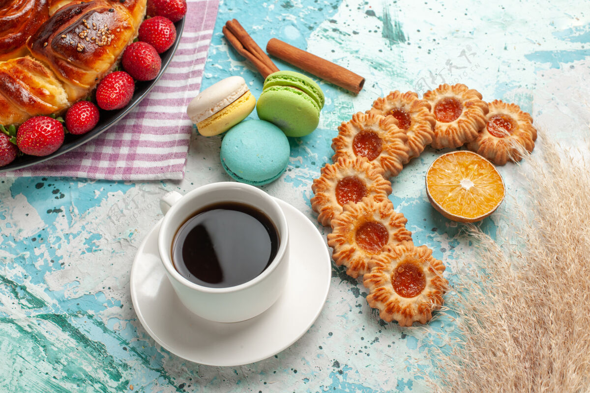 糖俯瞰美味的派与新鲜的红色草莓麦卡龙和茶杯浅蓝色的表面麦卡龙餐蛋糕