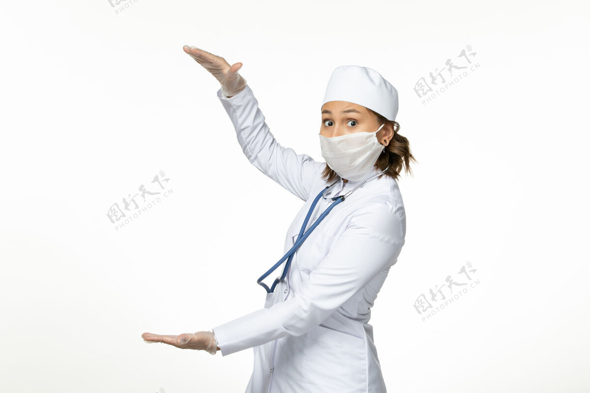 佩戴正面图年轻女医生戴防护无菌口罩因冠状病毒在浅白色表面病毒女性医生