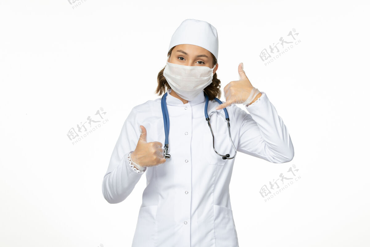药品正面图：年轻女医生 穿着白色医疗服 白色办公桌上有冠状病毒导致的无菌口罩女性冠状病毒大流行