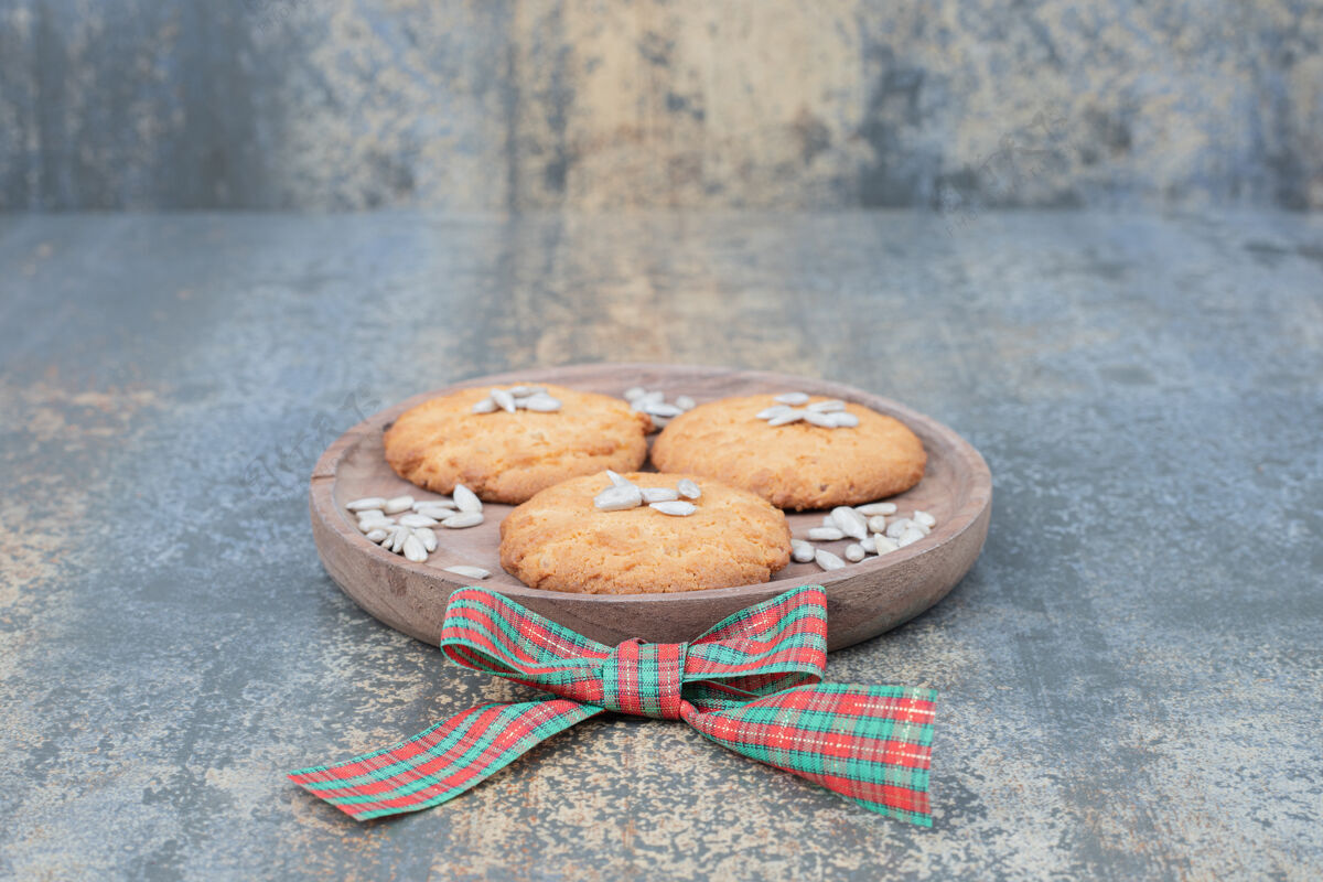 丝带用丝带装饰的木制盘子上有种子的圣诞饼干高质量的照片点心甜点糕点