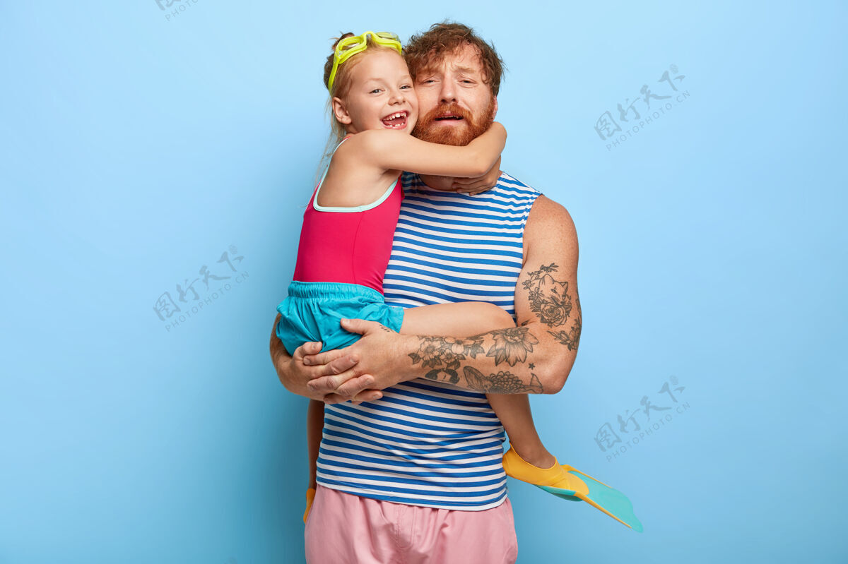 抱着疲惫的姜爸爸和女儿在游泳池里摆姿势小男性家庭