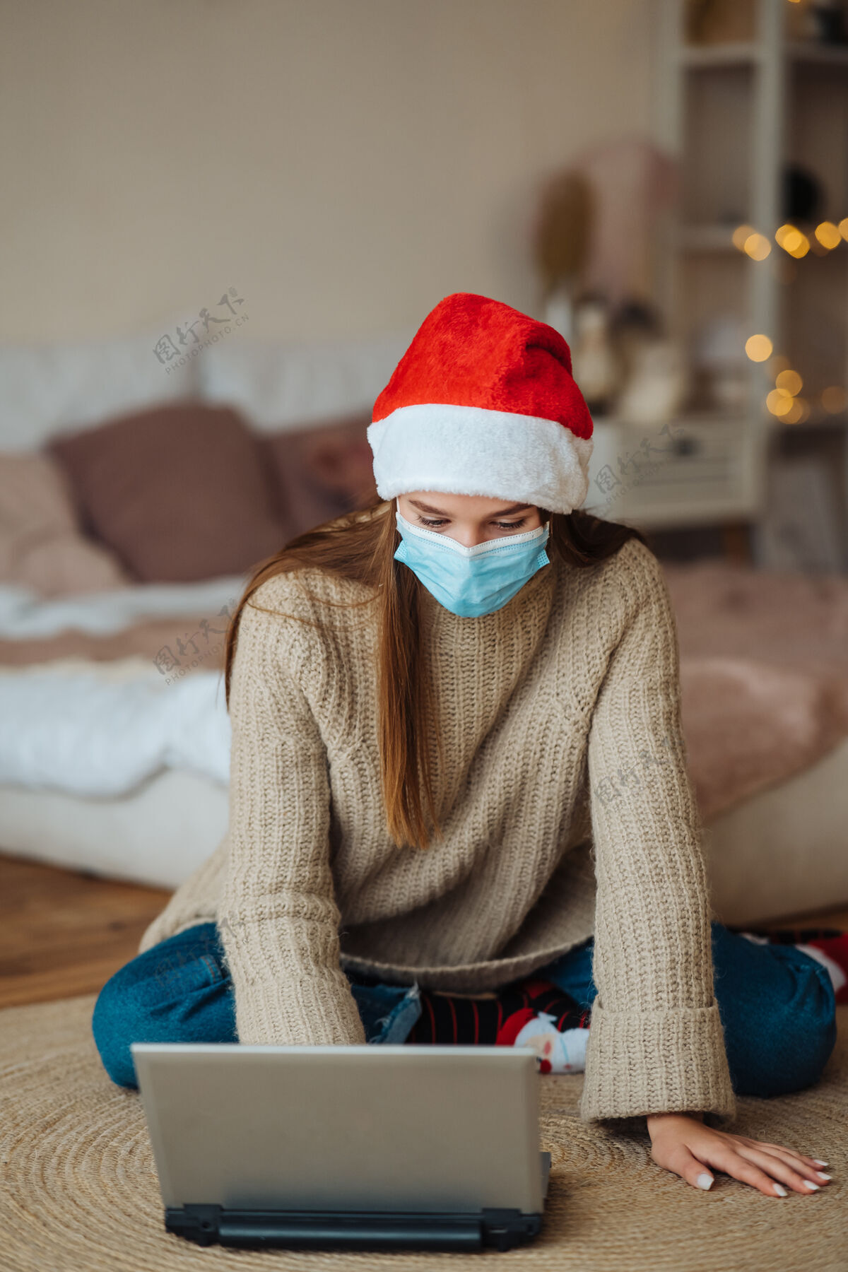 新的在家里庆祝圣诞节期间 女孩微笑着用笔记本电脑和网友交谈在冠状病毒的限制下庆祝新年和圣诞节的概念检疫中的节日面具保护流行病