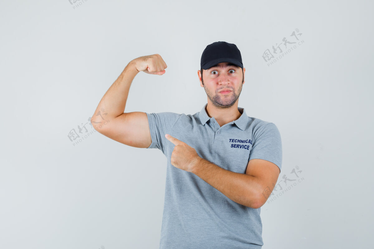 手臂年轻的技师指着穿着制服的手臂肌肉 看上去很自信成年人人肖像