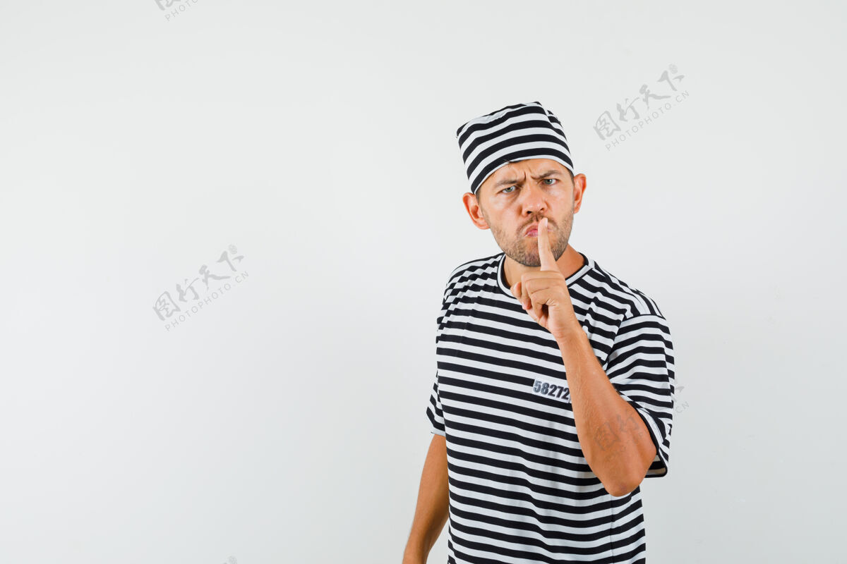 商人一个穿着条纹t恤 戴着帽子 看上去很小心的年轻人男人脸休闲