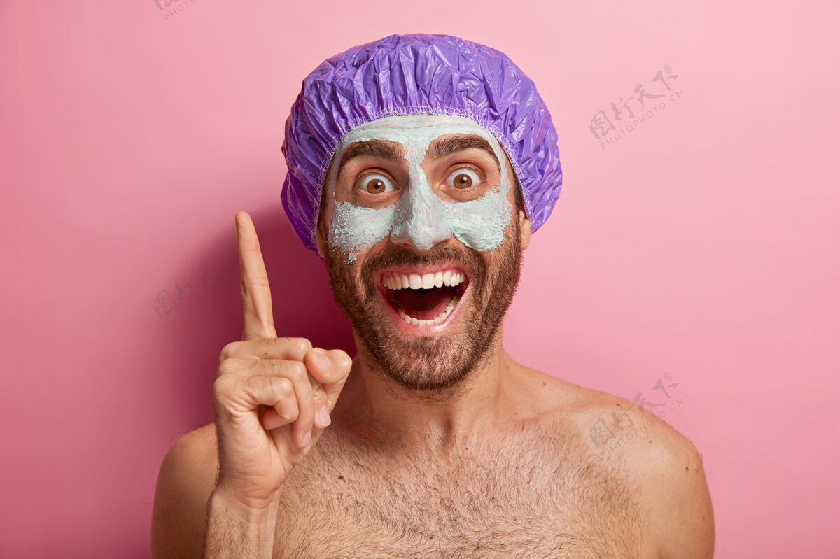 高兴快乐男模特写肖像抬起食指 向上指 脸上戴着泥面具健康躯干食指