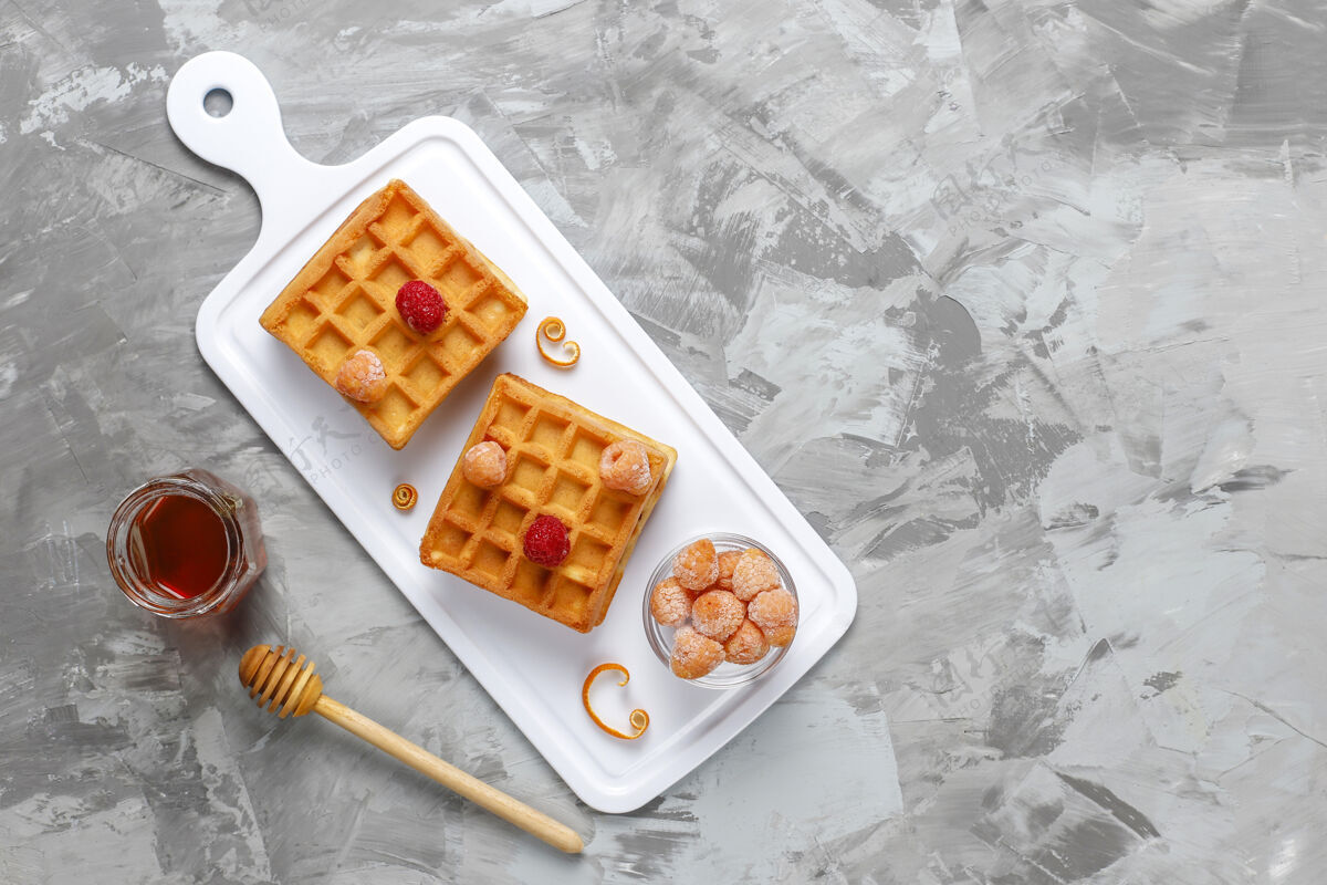 早餐传统比利时华夫饼配蜂蜜和冷冻浆果自然营养糕点