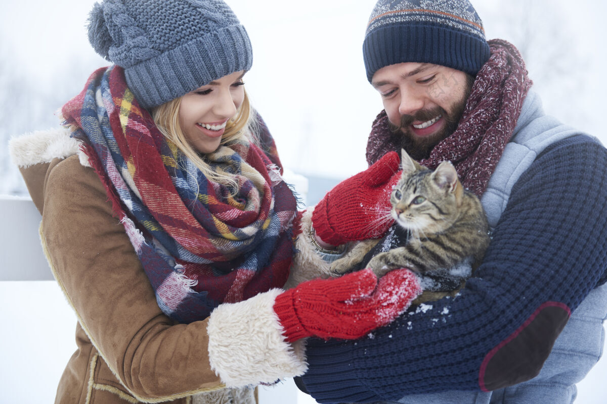 大笑冬天和猫在一起快乐的一对约会微笑手套