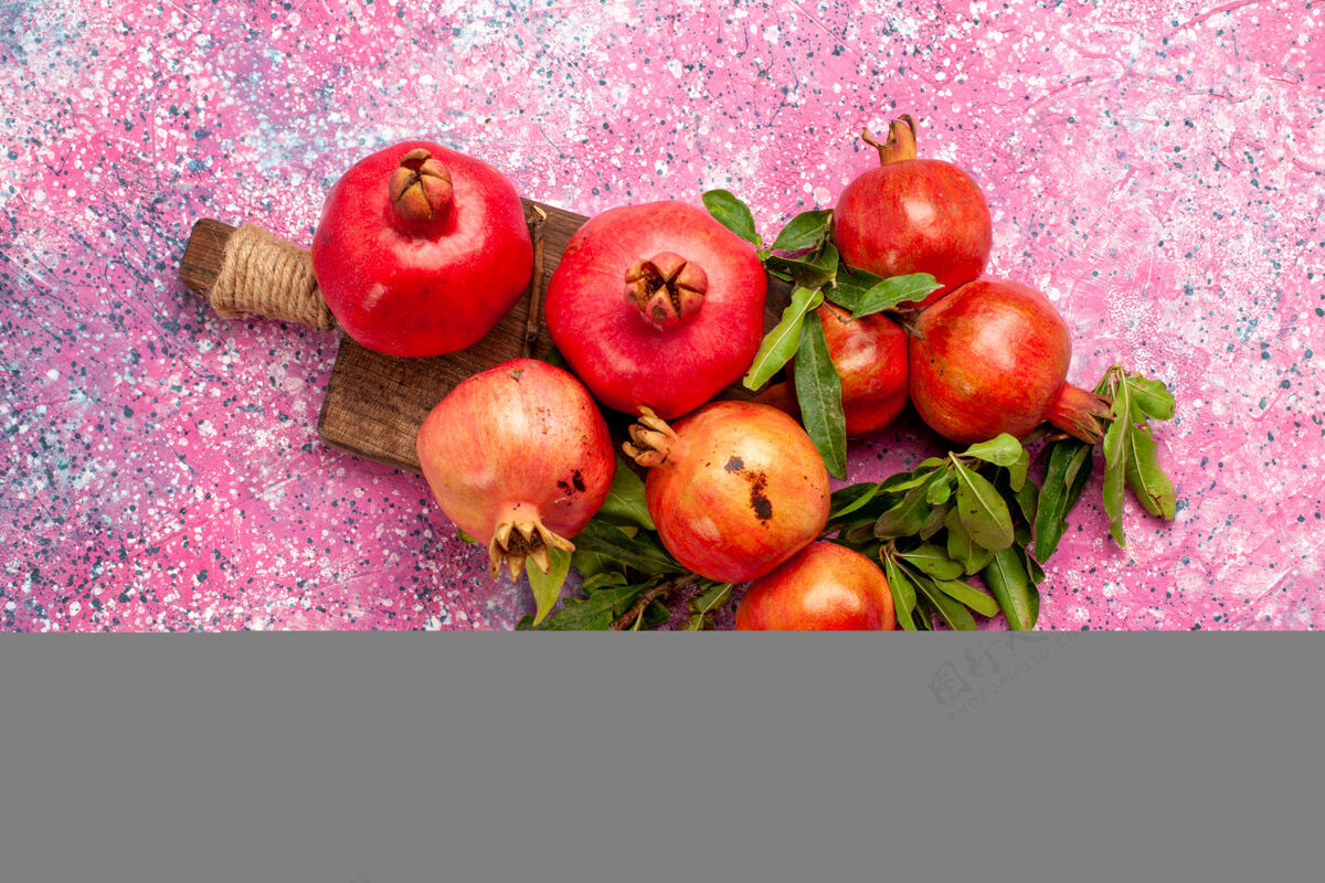 健康顶视图新鲜的红色石榴与绿色的叶子在粉红色的表面果汁石榴醇香