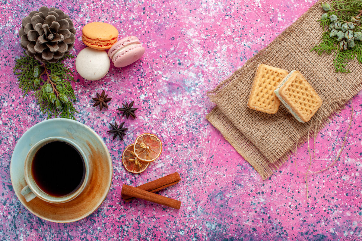咖啡俯瞰法式马卡龙美味的小蛋糕 粉色表面有茶和华夫饼饮料杯子小