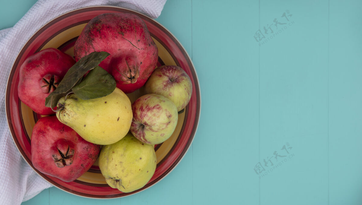 食物新鲜水果的顶视图 如石榴 木瓜和苹果 放在蓝色背景上的白布上 留有复制空间碗苹果膳食