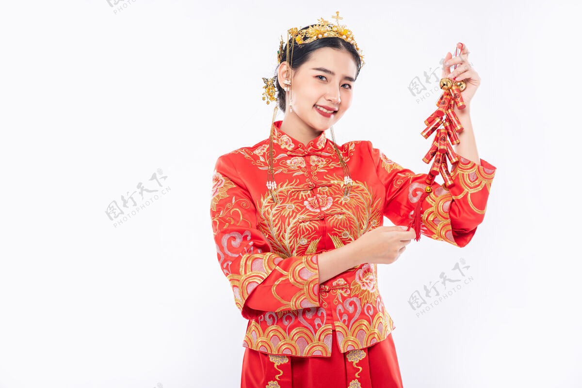 中国文化女人穿旗袍套装笑着从老板那里得到鞭炮在中国新年欢呼旗袍文化