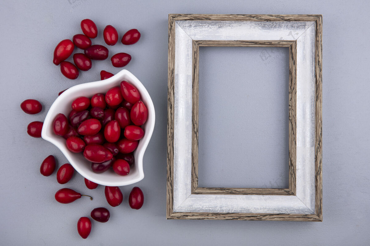 浆果新鲜的红色山茱萸浆果在一个灰色的背景上白色碗顶视图与复制空间山茱萸视图新鲜