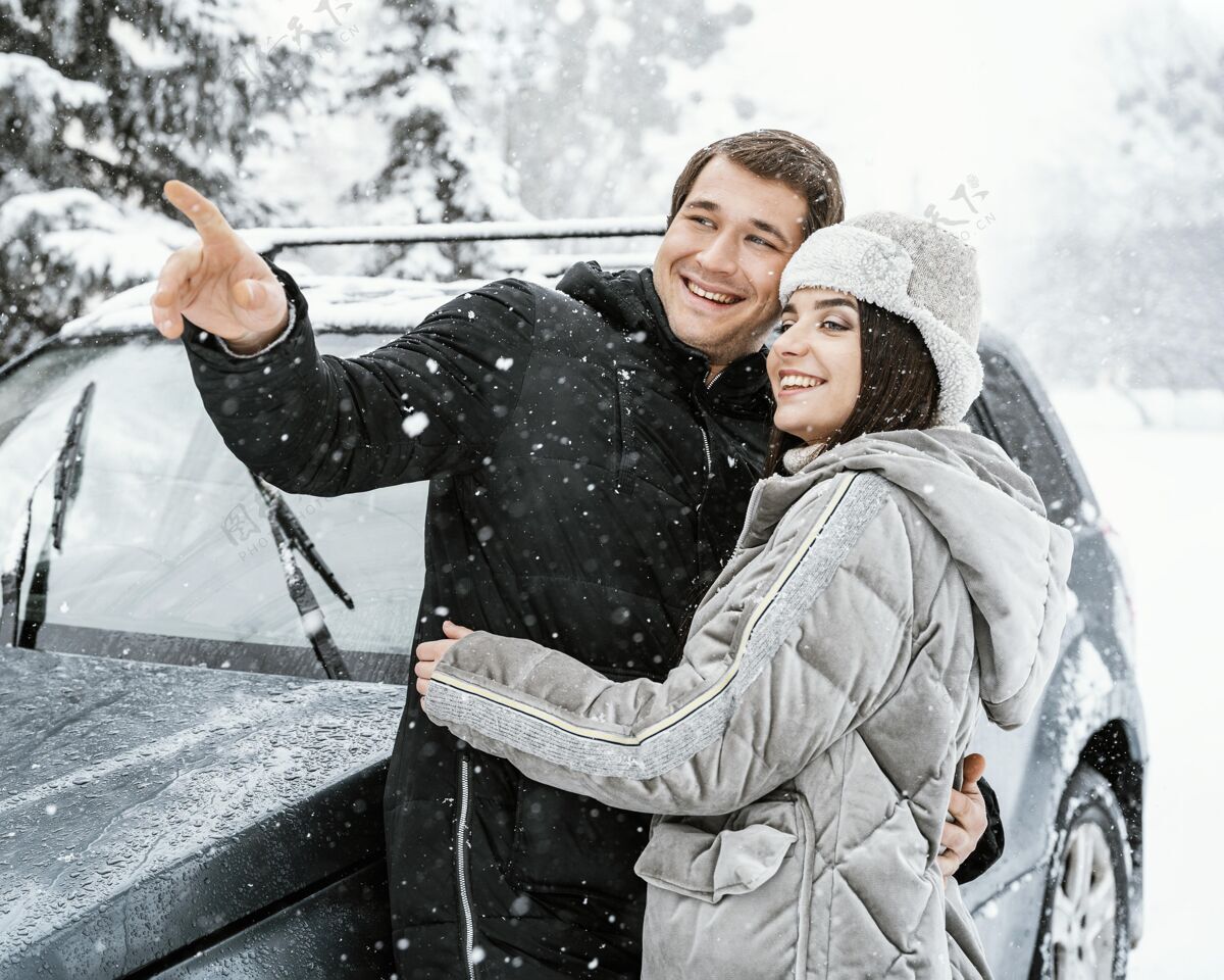 冬天一对微笑的情侣在路上的雪中拥抱男性逗留航行