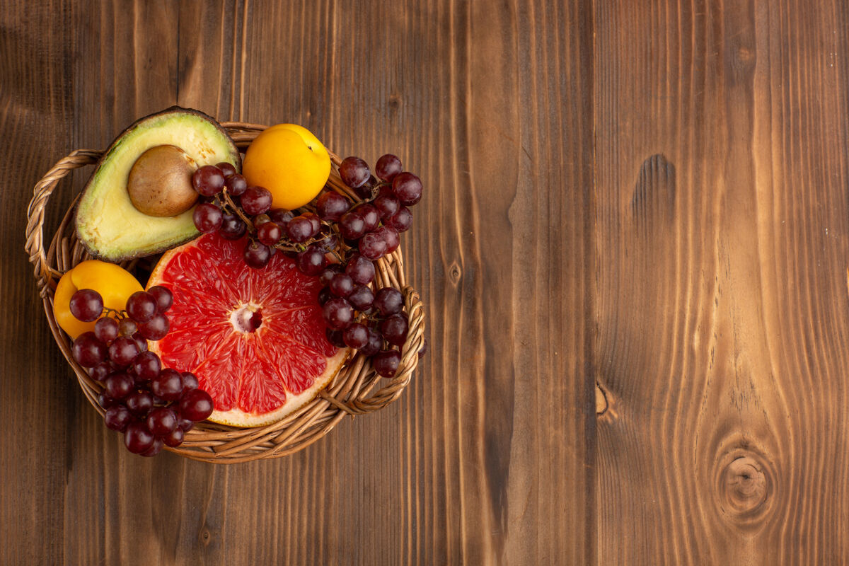 健康俯瞰棕色木质书桌上篮子里不同的水果食品内部桌子