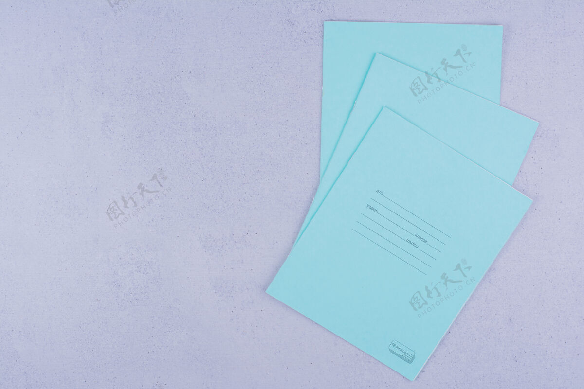 教育蓝色的笔记本孤立在灰色的表面上工作工具简约