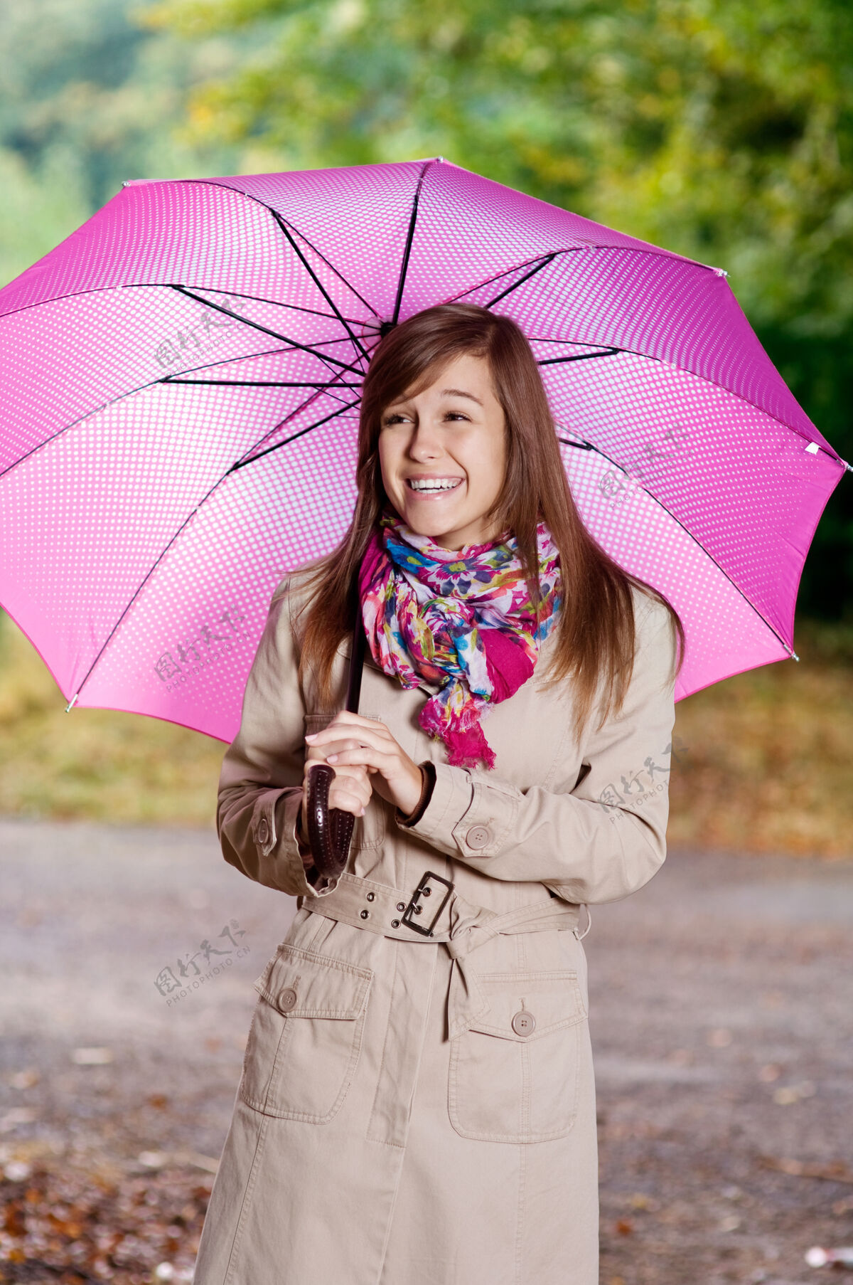 围巾带伞的可爱年轻女子散步雨伞人行道