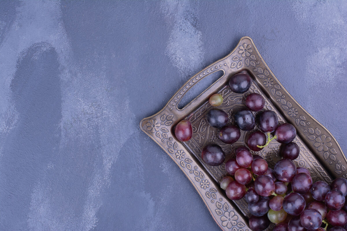 异国情调红葡萄放在蓝色表面的金属托盘里健康美味蔬菜