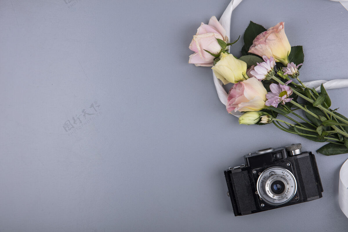 丝带顶视图的照片相机和花卉与丝带上的灰色背景与复制空间相机图片空间