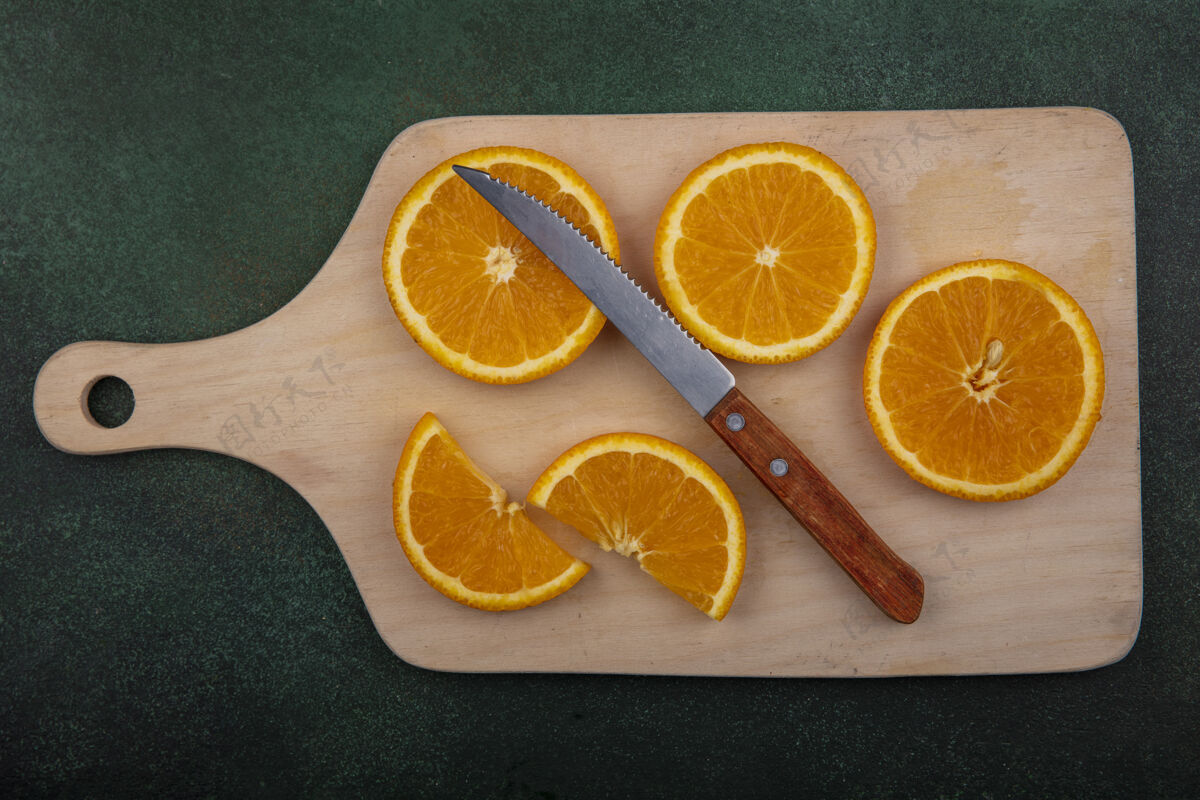 食物俯视图橙色切片与绿色背景上的刀切割板顶部查看刀