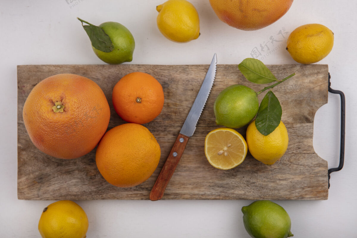 顶部顶视图柠檬橙子和葡萄柚与一个白色背景刀板上的酸橙刀白柑橘