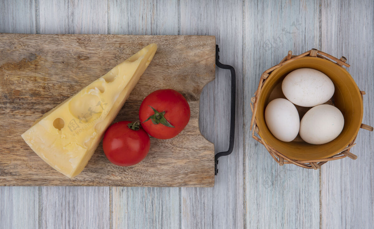 奶酪俯瞰玛斯丹奶酪 番茄放在架子上 鸡蛋放在灰色背景的篮子里灰色西红柿鸡蛋
