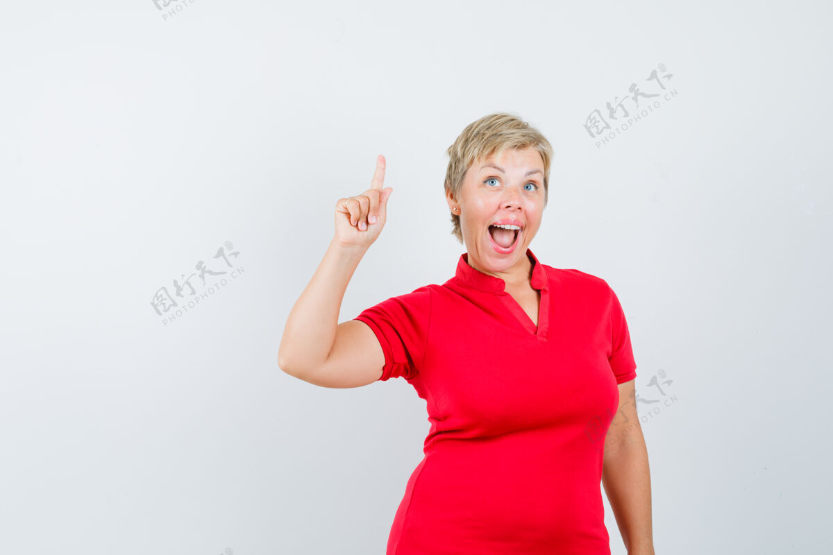 脸成熟的女人向上指着 穿着红色t恤有着绝妙的创意肖像看女士