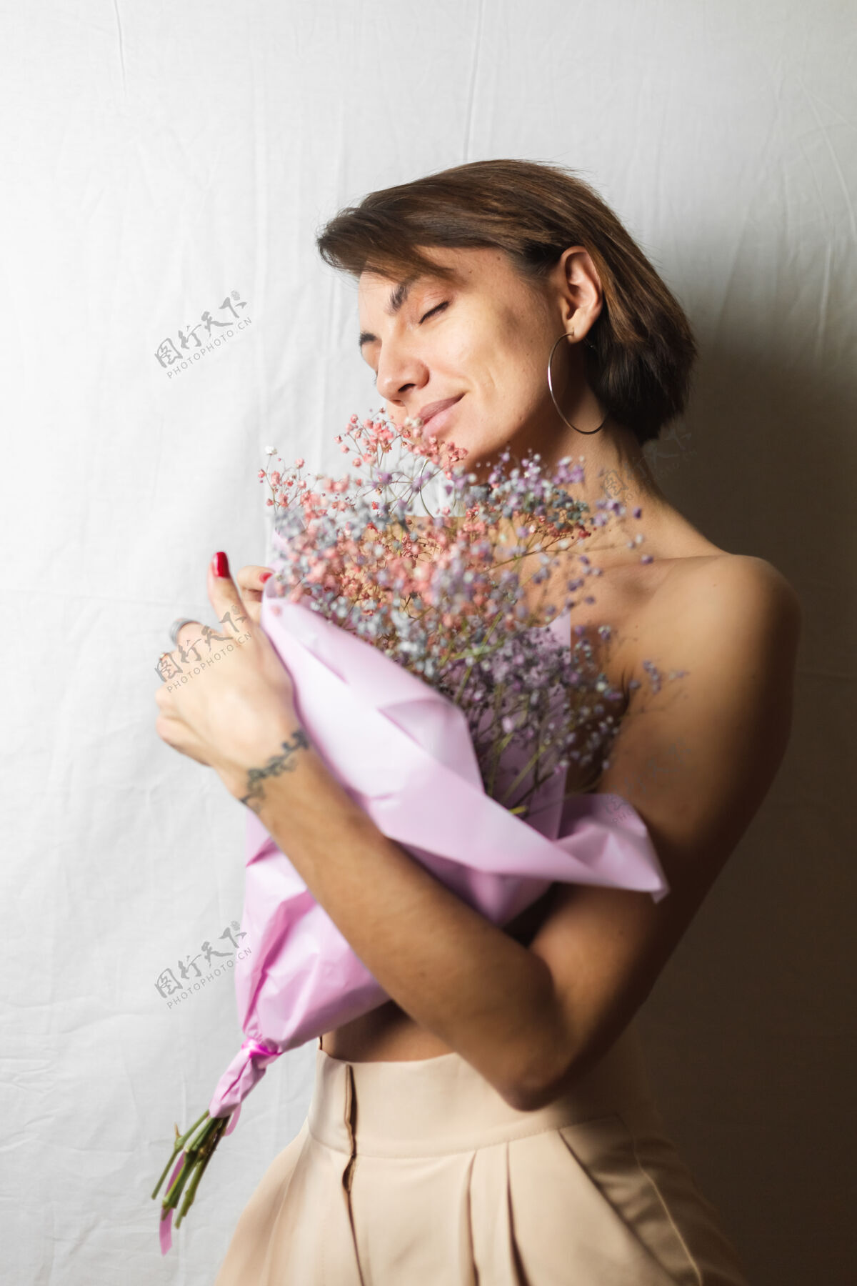 情感一位年轻女子的温柔写照 身穿白色抹布 赤裸上身 手持一束干枯多色的鲜花 微笑可爱 期待春天的到来社交植物花