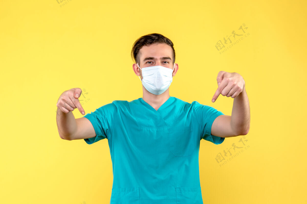 封面黄色墙上微笑的男医生的正面图男医生健康面具