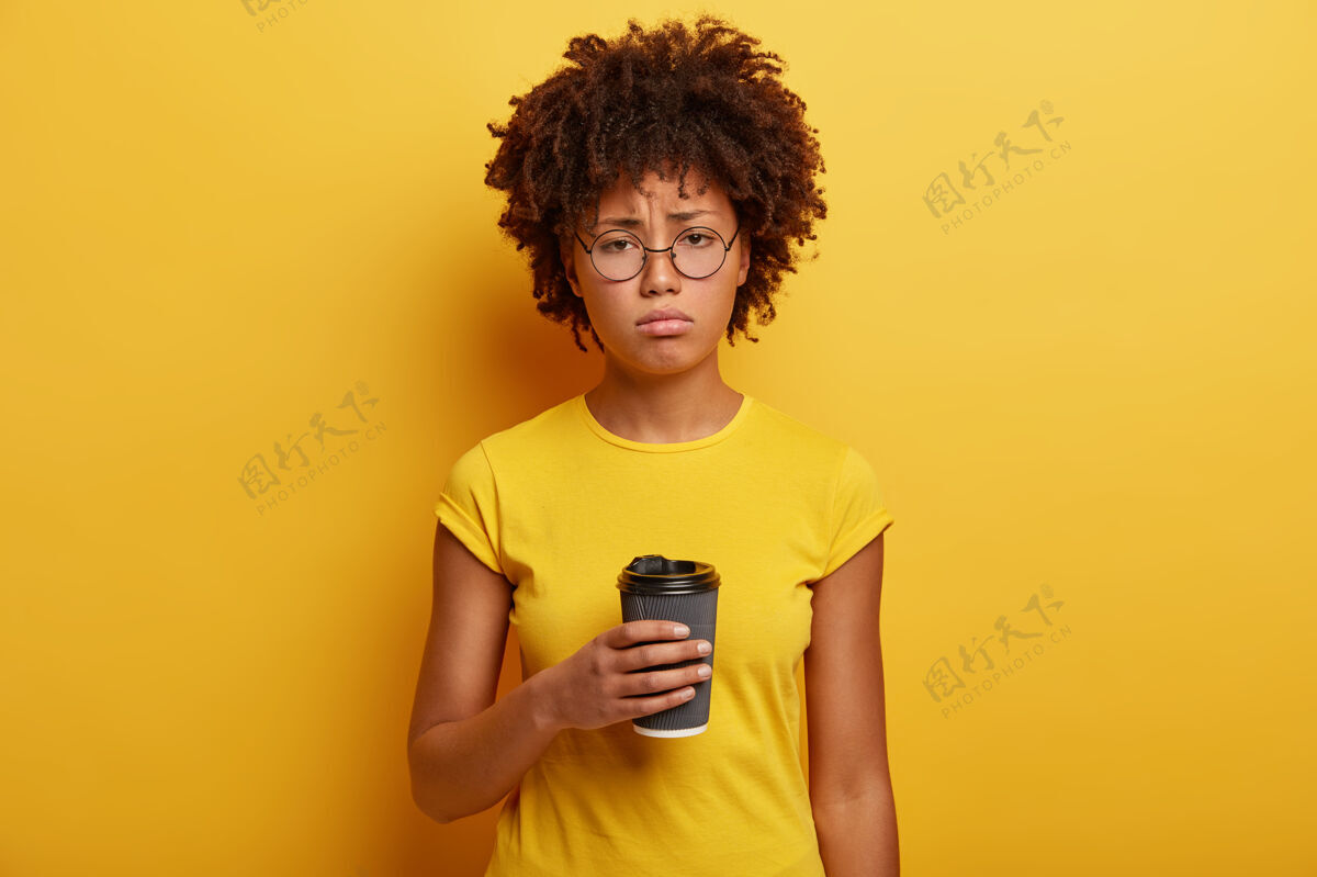 学生不开心的黑皮肤学生拿着一杯一次性咖啡因饮料杯子心烦女士