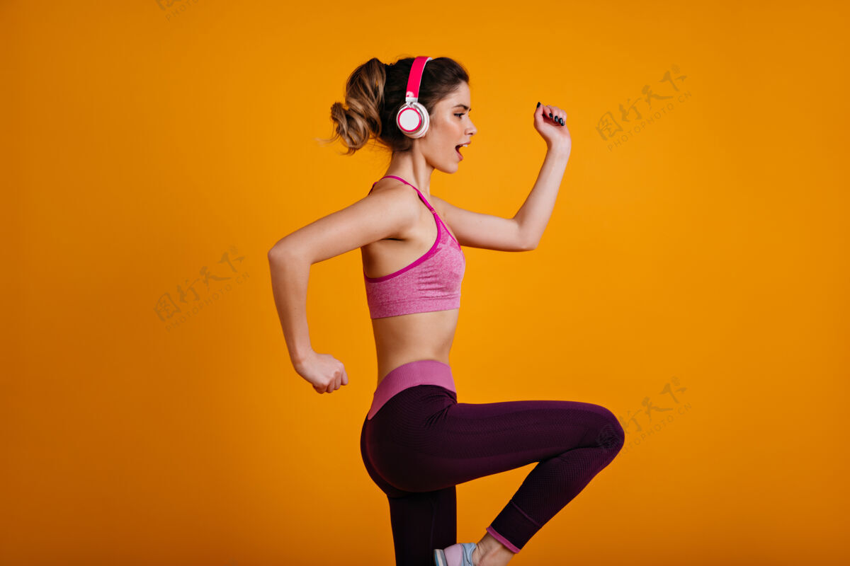成人自信的运动型女子耳机训练运动装女性交叉健身