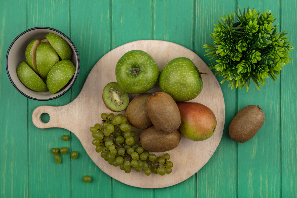 苹果俯视绿色的背景上的立场上的猕猴桃绿色葡萄和梨绿色苹果顶部观点新鲜