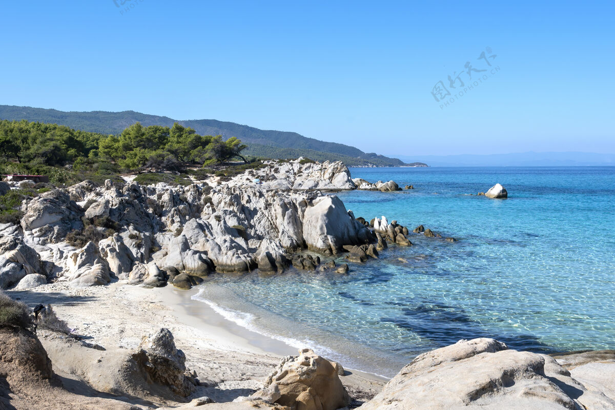 爱琴海爱琴海沿岸绿树成荫 岩石 灌木和树木 蓝色的海水 希腊海岸山海景