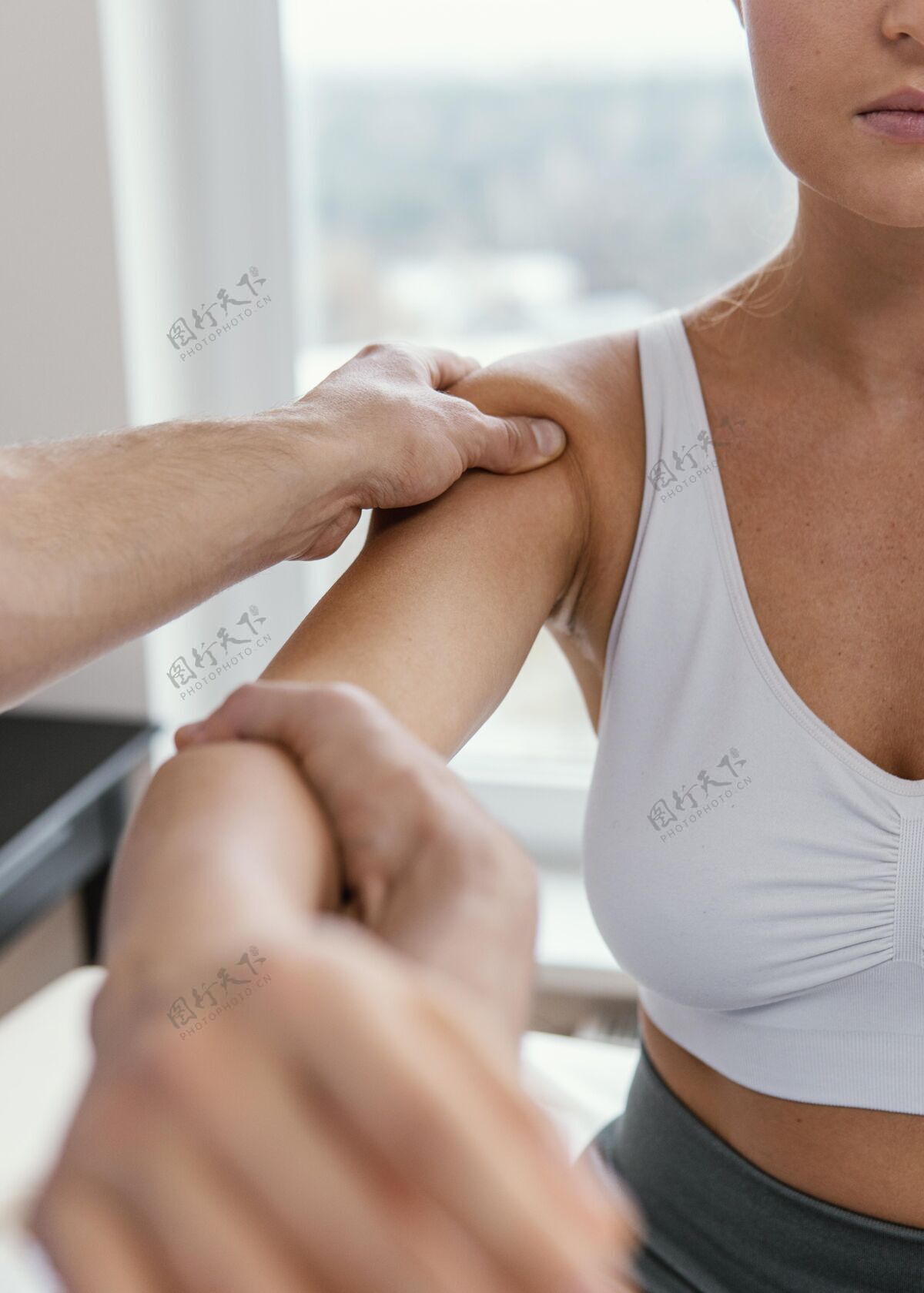 女人男性骨科治疗师正在检查女性患者的肩膀男人健康运动