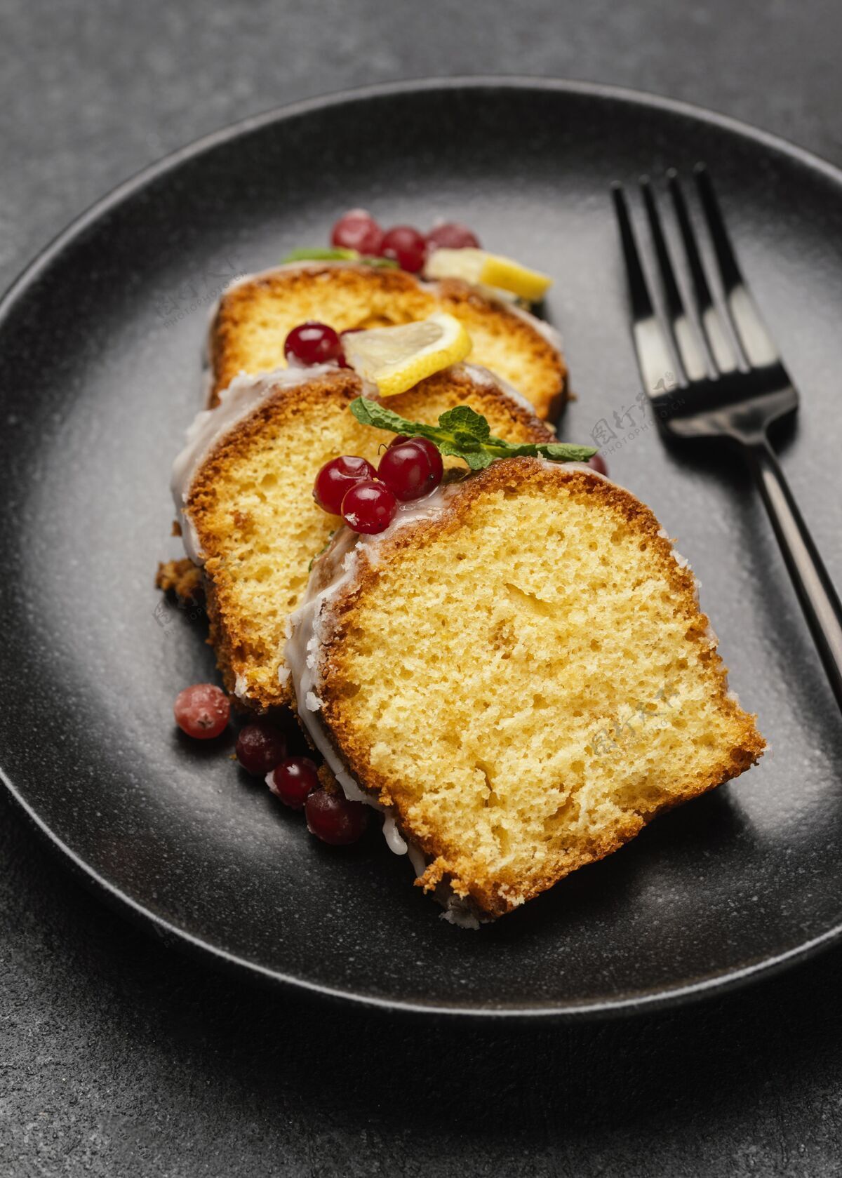 甜点用叉子和浆果把蛋糕片放在盘子里特写镜头小吃糖果美食