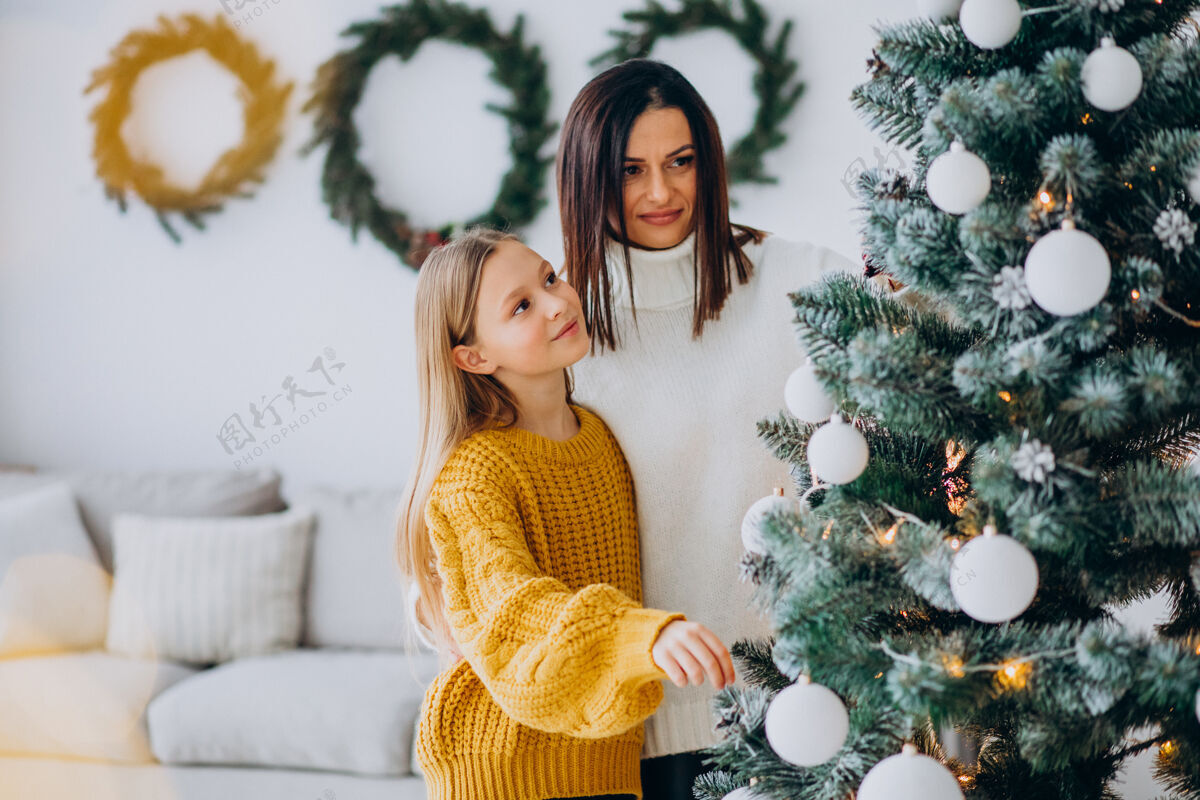 惊喜妈妈带着女儿装饰圣诞树乐趣房子家庭