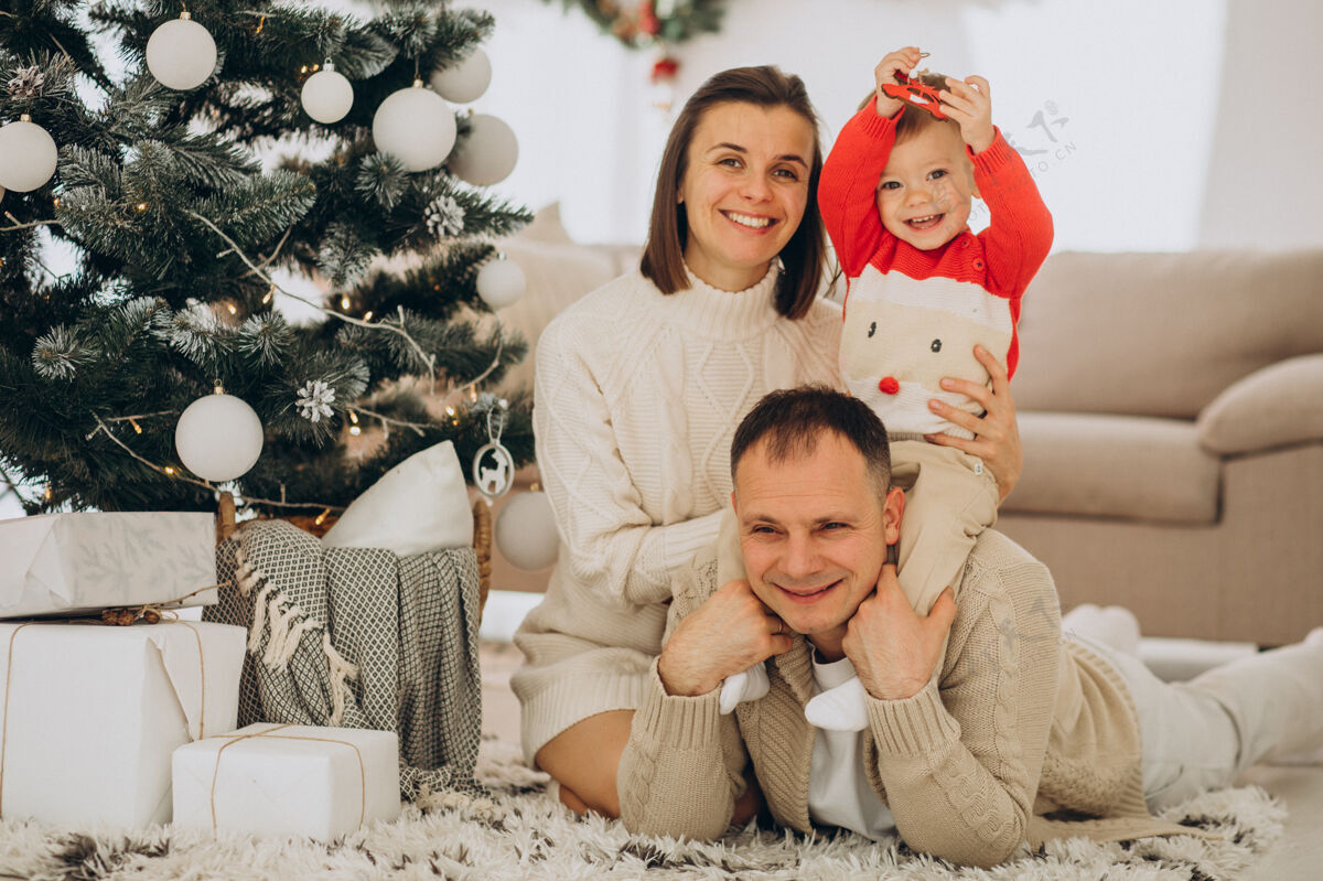 装饰一家人带着小儿子在家里的圣诞树旁过圣诞节人父母休闲