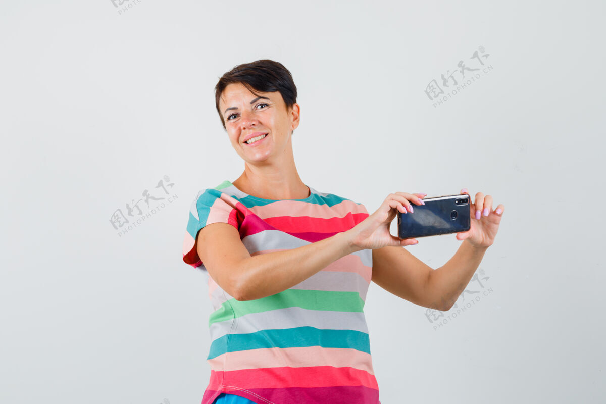 年轻人穿着条纹t恤的女性在手机上拍照 看起来很快乐 正面图服用面罩疾病